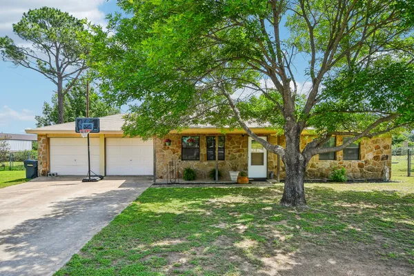 a front view of a house with a yard and trees