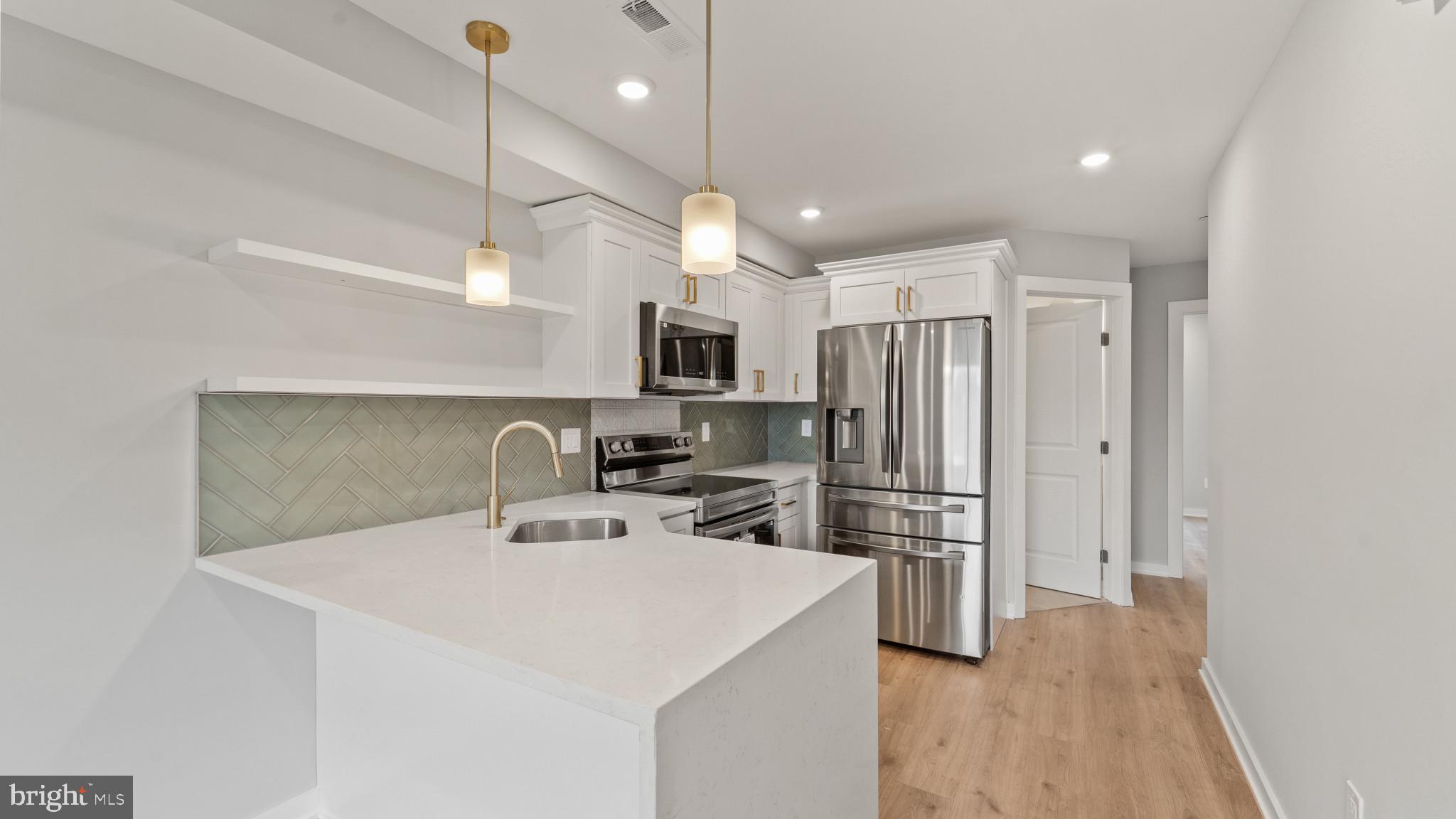 1432 Ogden Street, Unit 2 Philadelphia, PA 19130 - Photo 4 of 16 a kitchen with kitchen island a refrigerator sink and stove