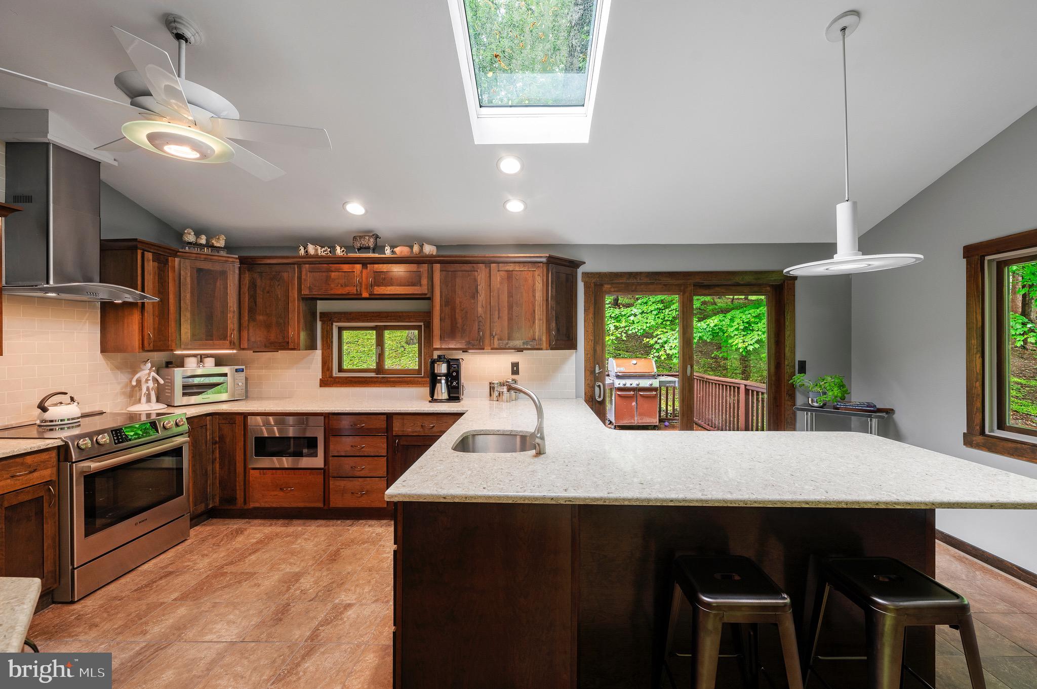 813 Old State Road Berwyn, PA 19312 - Photo 39 of 64 a kitchen with a stove a sink a microwave a dining table and chairs