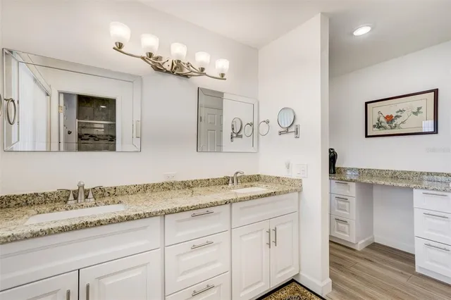 a bathroom with a granite countertop sink and a mirror