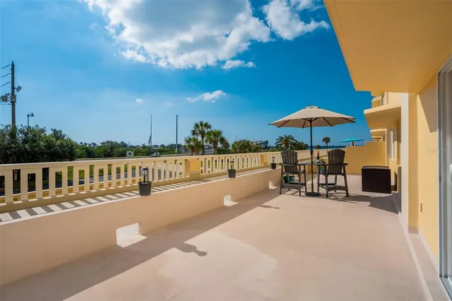 a view of a chair and tables under an umbrella in patio