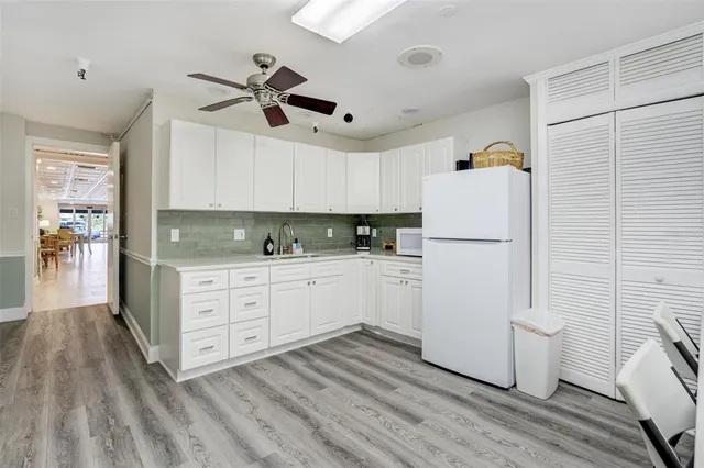a kitchen with a refrigerator and white cabinets
