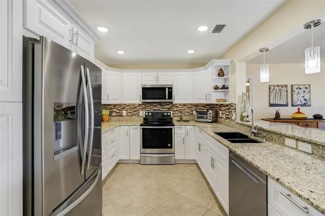 a large kitchen with a refrigerator sink and stainless steel appliances