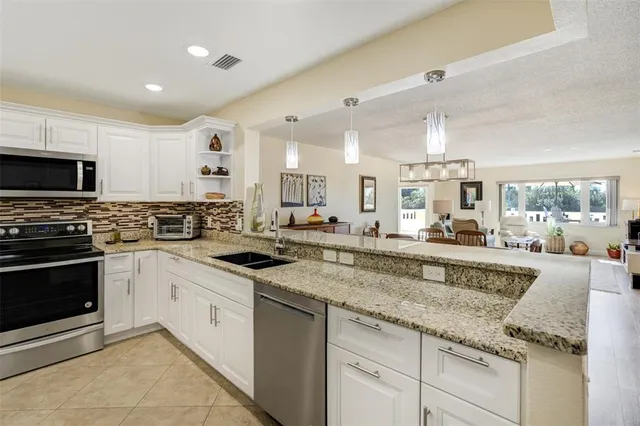 a kitchen with granite countertop a sink and white cabinets