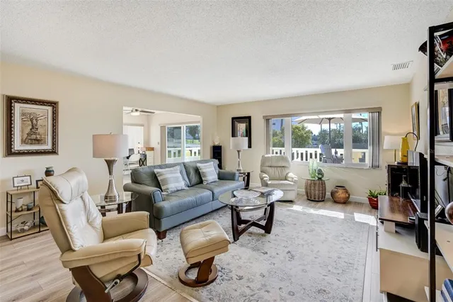 a living room with furniture a flat screen tv and a large window