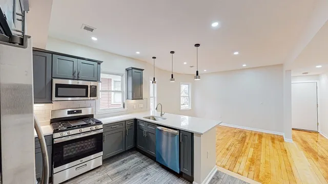 a kitchen with stainless steel appliances kitchen island granite countertop a stove and a sink