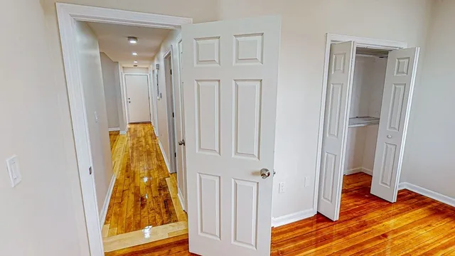 wooden floor with closet and mirror