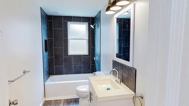 a bathroom with a tub sink and mirror
