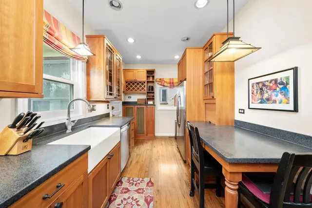 a kitchen with stainless steel appliances granite countertop a sink a stove and a wooden floors