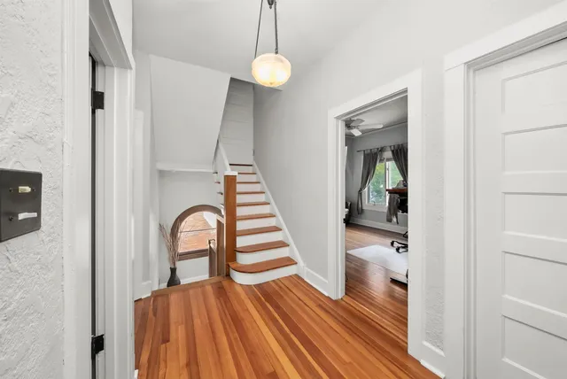 a view of a hallway with wooden floor and staircase