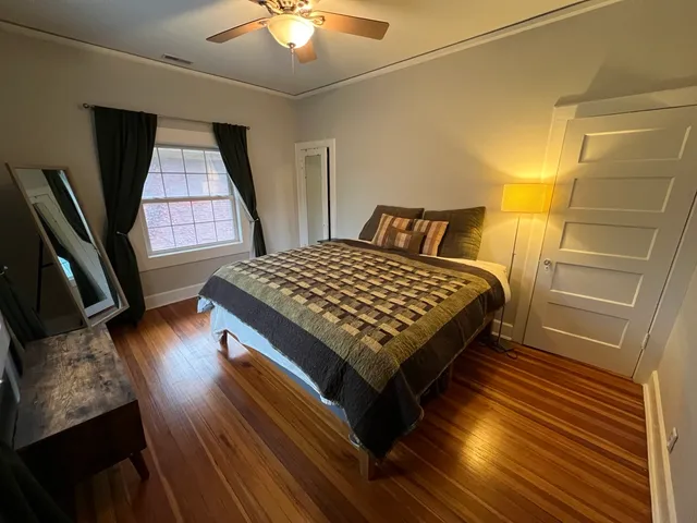 a bedroom with a bed and wooden floor