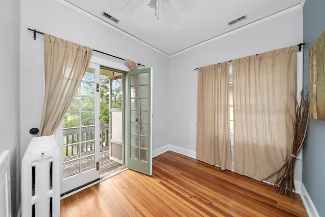 a view of a bedroom with wooden floor and windows