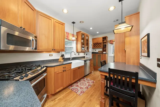 a kitchen with stainless steel appliances granite countertop a stove a sink and a microwave