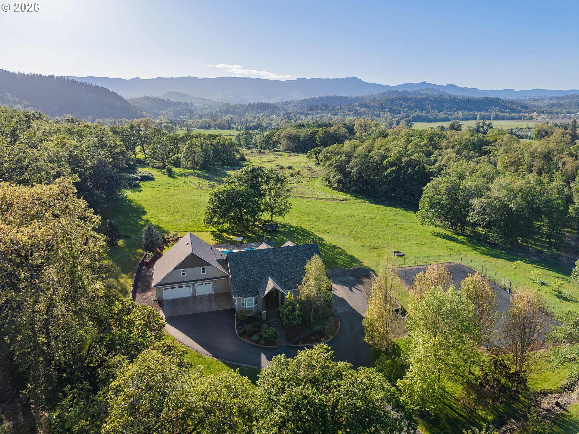 2700 Melrose Road Roseburg, OR 97471 - Photo 4 of 48 a view of a lush green field with mountains in the background