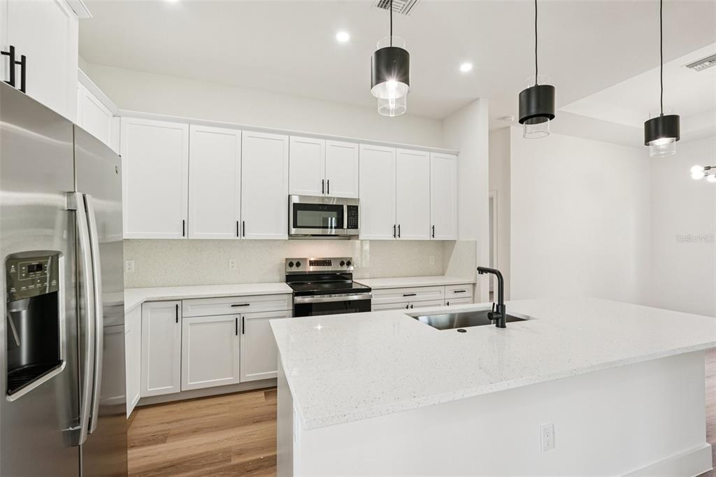 1852 Rada Lane North Port, FL 34288 - Photo 12 of 29 a kitchen with kitchen island white cabinets and stainless steel appliances