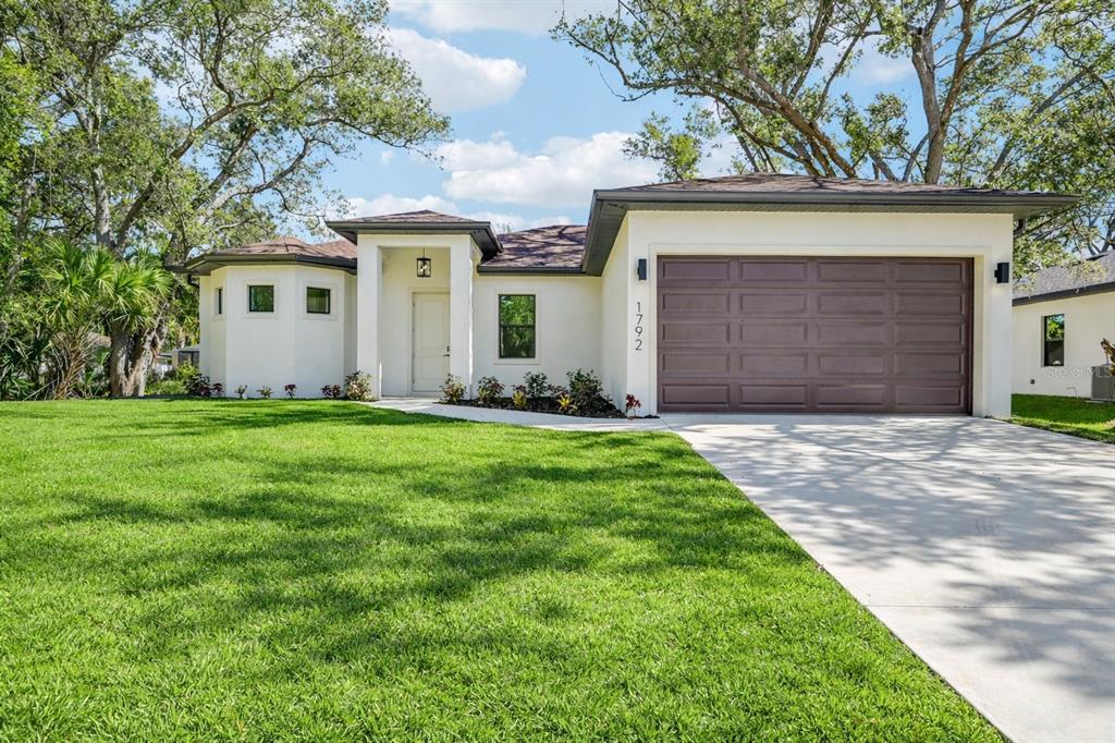 1852 Rada Lane North Port, FL 34288 - Photo 2 of 29 a front view of a house with a yard and garage
