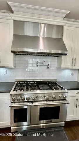 a stove top oven sitting inside of a kitchen