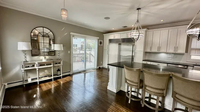 a view of a kitchen with fridge and wooden floor