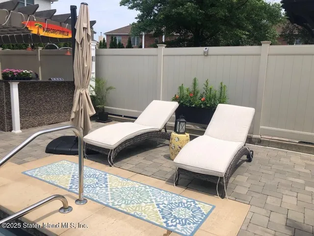 a view of a patio with table and chairs with wooden floor and fence