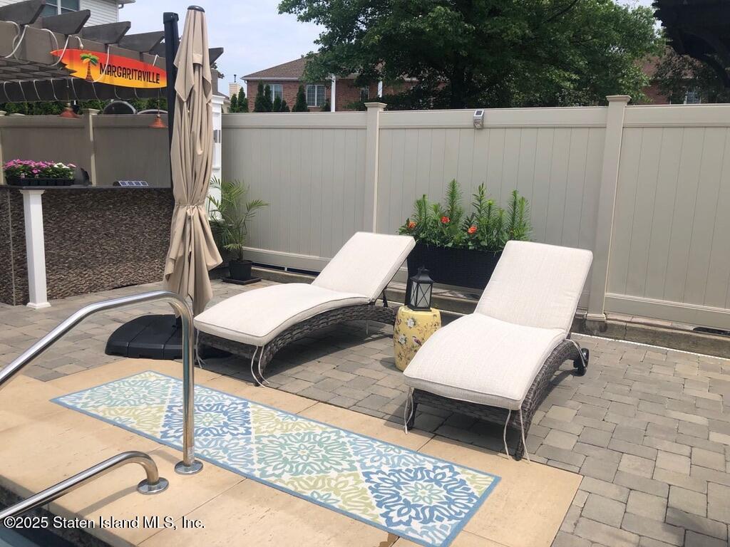 998 Annadale Road Staten Island, NY 10312 - Photo 40 of 46 a view of a patio with table and chairs with wooden floor and fence