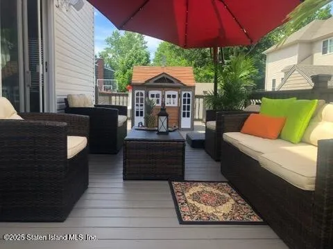 a view of a patio with couches chairs under an umbrella