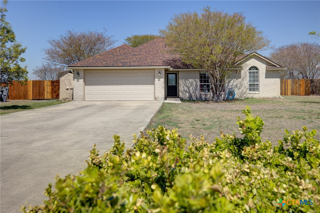 a front view of a house with a garden and yard
