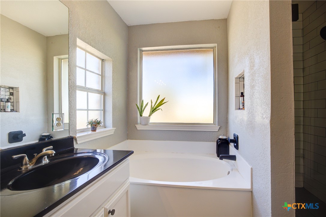 940 Cordova Loop Seguin, TX 78155 - Photo 11 of 32 a bathroom with a tub sink and mirror