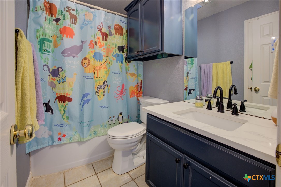 940 Cordova Loop Seguin, TX 78155 - Photo 17 of 32 a bathroom with a sink toilet and shower curtain