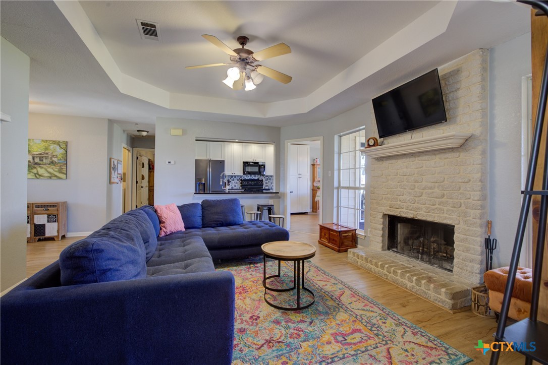 940 Cordova Loop Seguin, TX 78155 - Photo 3 of 32 a living room with furniture a fireplace and a flat screen tv