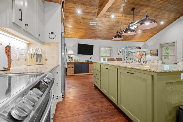 a kitchen with stainless steel appliances granite countertop a sink stove and cabinets