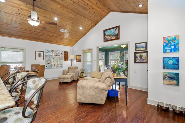 a living room with furniture a flat screen tv and kitchen view