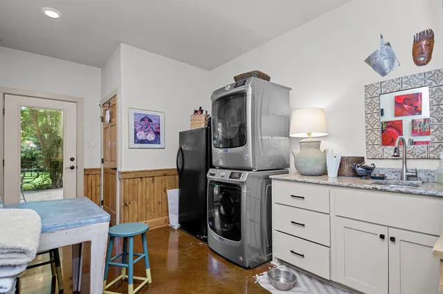 a kitchen with stainless steel appliances granite countertop a refrigerator a stove a sink and a dining table with wooden floor