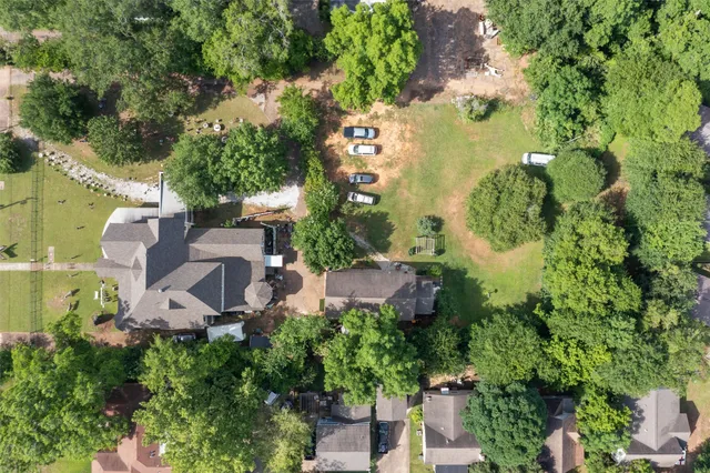 an aerial view of residential houses with city and green space