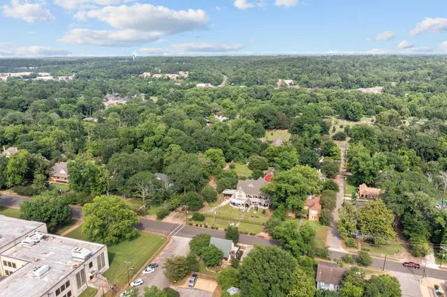an aerial view of a house with swimming pool a yard and a garage