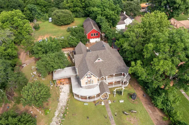 a aerial view of a house with swimming pool and large trees
