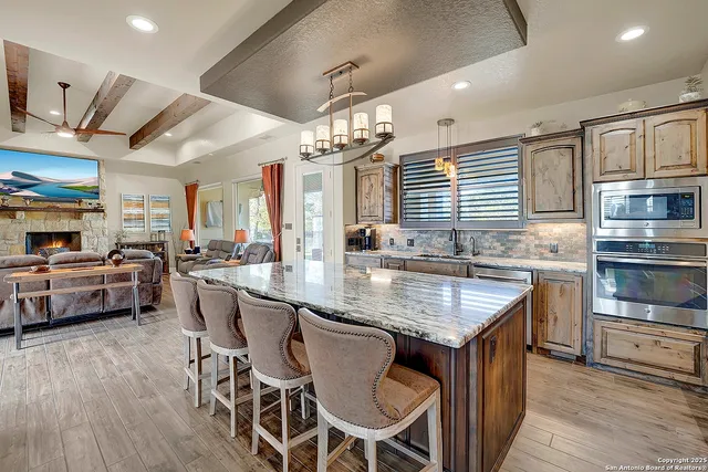 a kitchen with stainless steel appliances granite countertop a kitchen island a stove and a sink