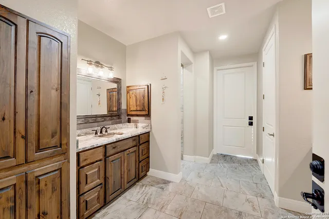 a spacious bathroom with a double vanity sink a mirror and a shower