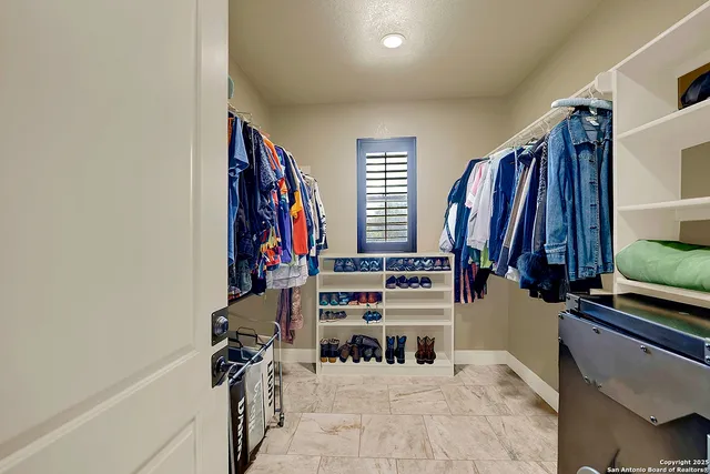 a view of walk in closet with clothes and shoes