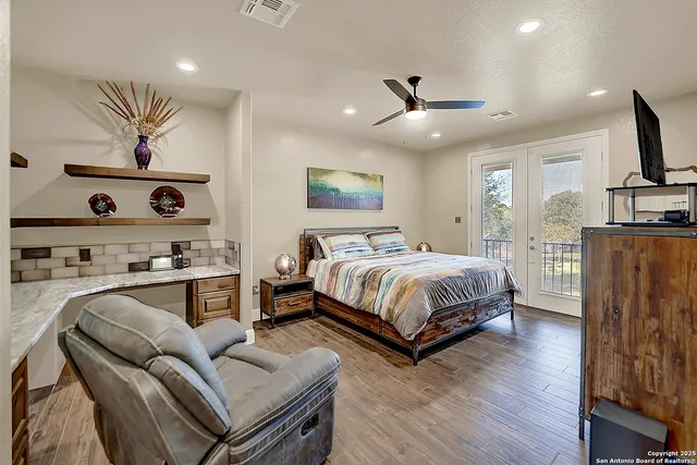 a spacious bedroom with a bed window and a flat screen tv
