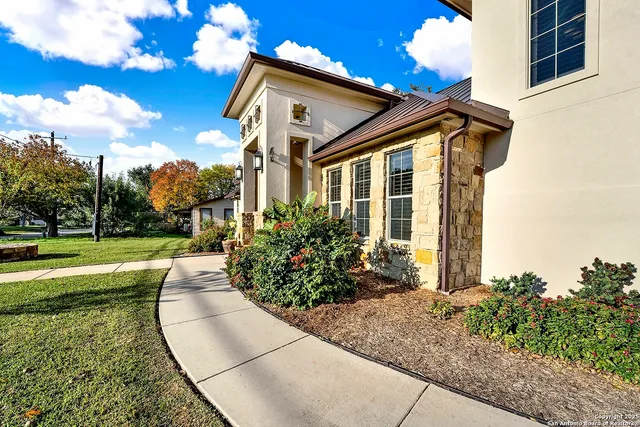 a view of a house with a big yard and potted plants