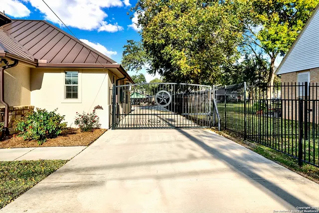 a view of a house with a small yard plants and a large tree