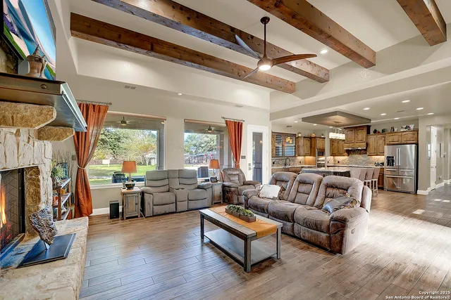 a living room with fireplace furniture and a large window
