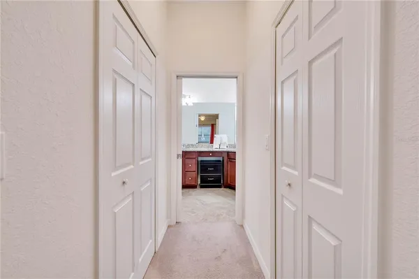 a view of a hallway with entryway windows chandelier and a kitchen view