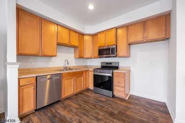 a kitchen with stainless steel appliances granite countertop a stove a sink and a microwave