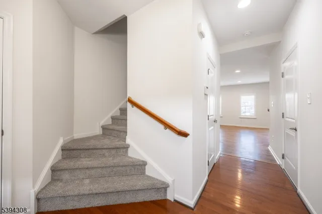 a view of a hallway with wooden floor and staircase