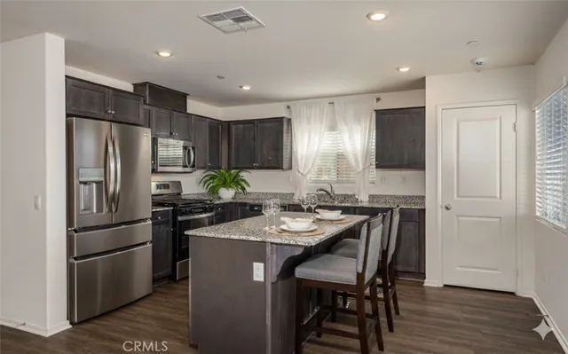 a kitchen with refrigerator a sink and chairs
