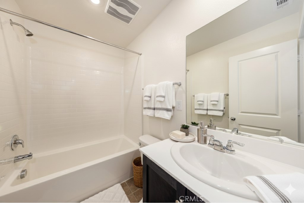1455 Honor Way Hemet, CA 92543 - Photo 8 of 15 a bathroom with a bathtub shower sink vanity and a mirror