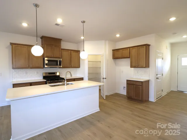 a kitchen with wooden cabinets and stainless steel appliances
