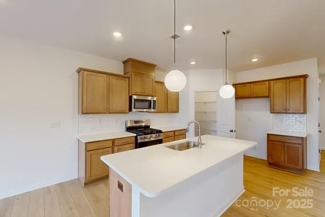 a kitchen with stainless steel appliances a stove a sink and a refrigerator