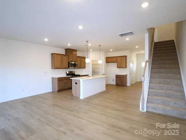 a large kitchen with stainless steel appliances kitchen island granite countertop a stove and a sink